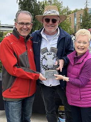 photo of three people holding a trophy